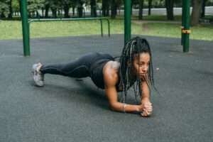 a woman doing planking workout at a park