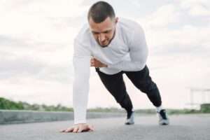 a man doing planking outdoors, one of the 10 best fitness exercises