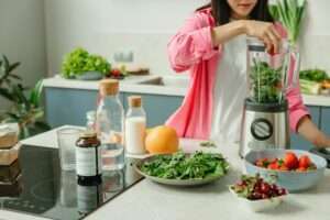 a woman using a blender, one of the top 10 health and fitness gadgets 