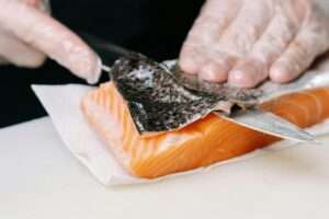 a-person-removing-the-skin-of-a-salmon, one of the super-foods for healthy life