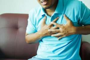 a man in blue polo shirt holding his chest