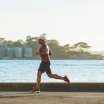 man running near sea during daytime, an example of the best cardio workouts for burn fats.