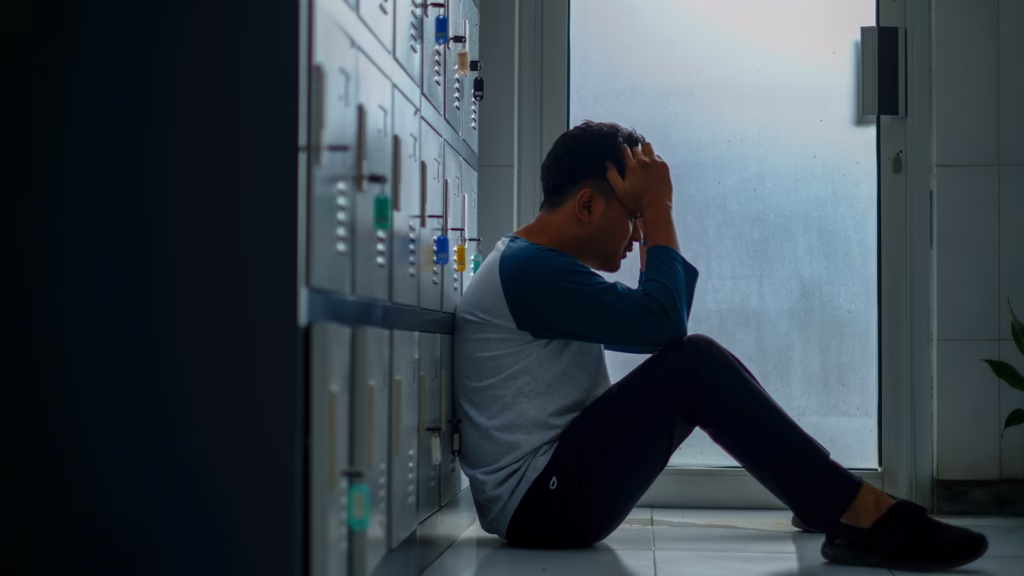 man in gray long sleeve shirt and black pants sitting on white floor tiles-How to Fix the Effects of Stress on Your Body